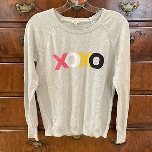 Project sweater with XOXO on front.